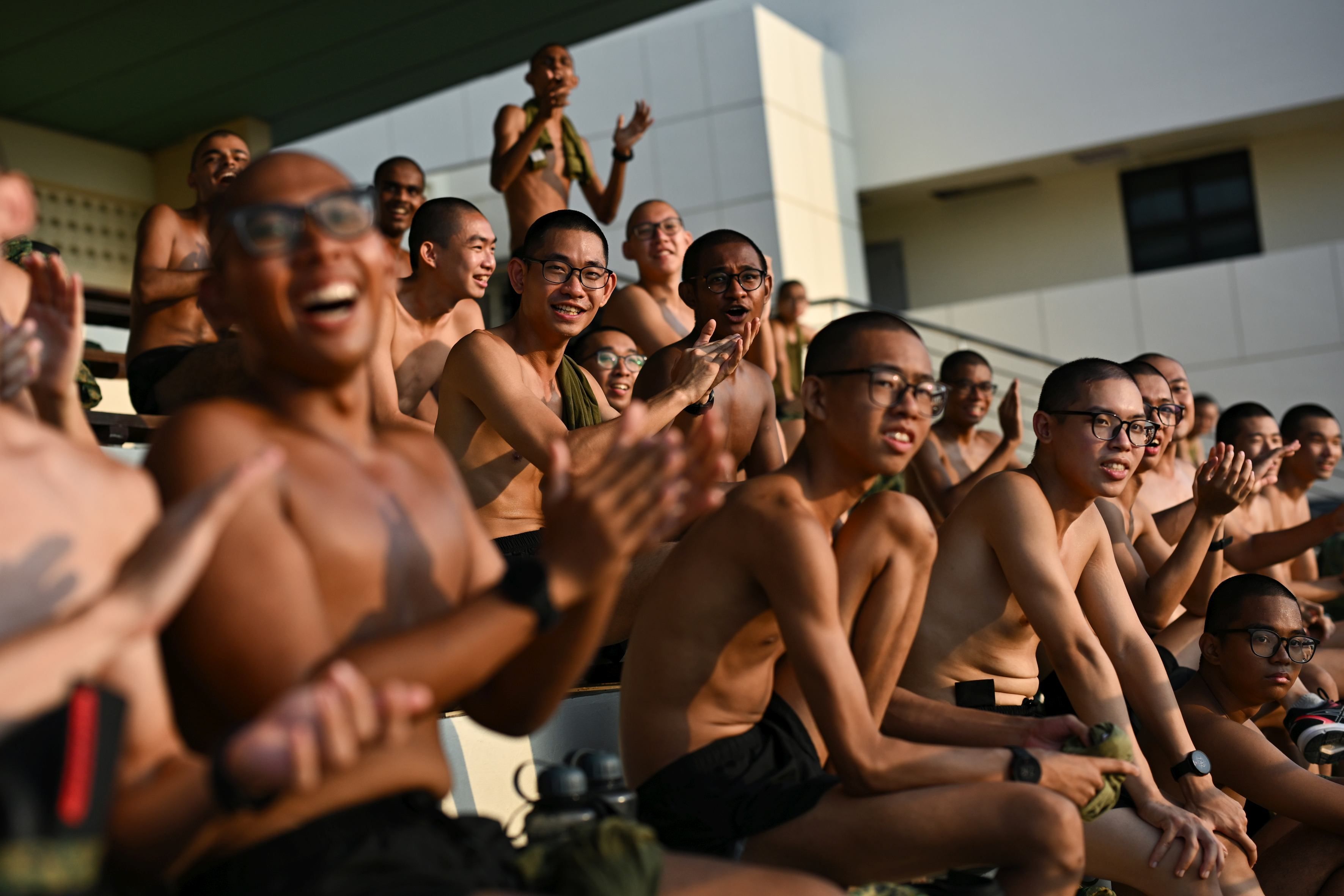 A group of men cheers during a physical test at the Basic Military Training Centre in Pulau Tekong.
